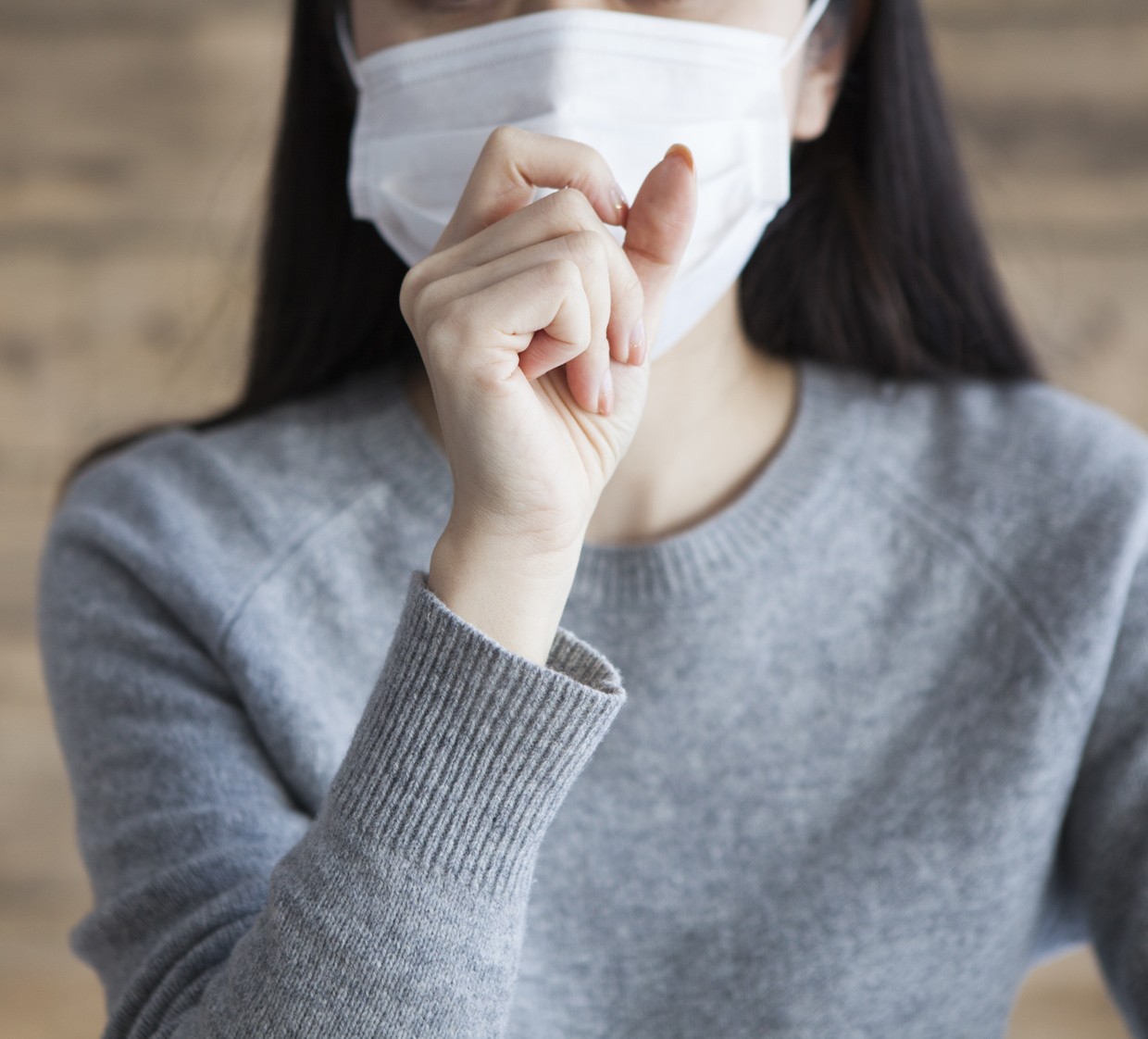 Woman wearing a mask has a cough