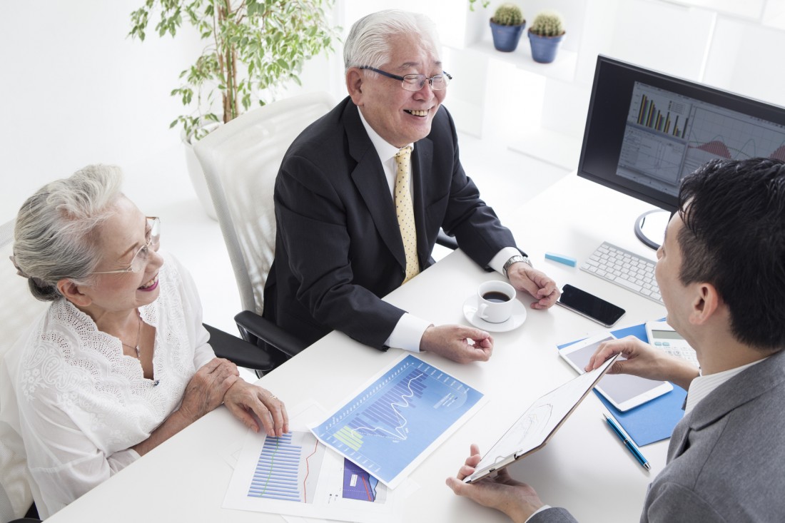 Sales person and old couple are simulating real estate investment